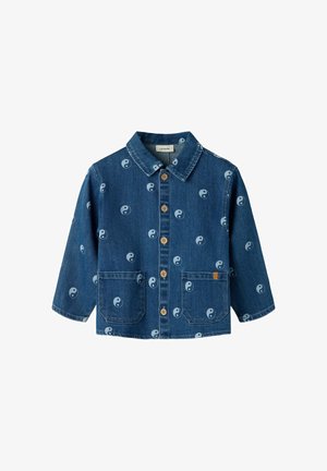 Blauwe spijkerjas met knoopsluiting aan de voorkant, twee voorzakken en een patroon van witte yin-yang symbolen overal.