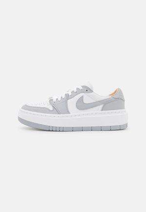 Zapatilla blanca de corte bajo con superposiciones gris claro, logo Swoosh gris, cordones blancos y suela gruesa blanca con detalles de la banda de rodadura en gris.