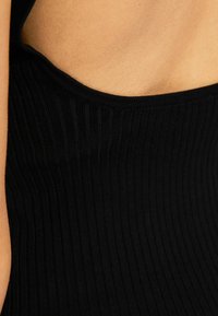 Musta, resorikuvioitu body, jossa on pyöreä pääntie ja sileä pinta, korostaen pystysuoria linjoja ja vartalonmyötäistä siluettia.