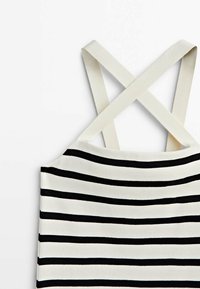 Haut à bretelles avec des bretelles blanches croisées. Le tissu présente des rayures horizontales noires et blanches, une texture lisse, et une coupe ajustée.