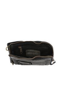 Sac en cuir noir avec une ouverture zippée, une poche intérieure zippée et une fente plate. Présente des coutures visibles et une boucle en métal.