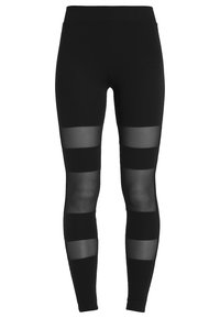 Leggings noirs avec des panneaux en maille transparente disposés en rayures horizontales, dotés d'une taille haute et d'une texture de tissu lisse et extensible.