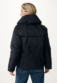 Veste doudoune noire avec un col haut, texture matelassée et coupe décontractée. Présente un extérieur lisse et brillant. Convient pour le temps froid.