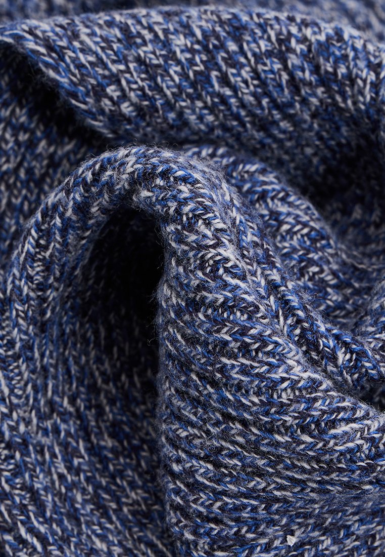 Tissu tissé dans des nuances de bleu et de gris, présentant un motif en chevrons avec une finition texturée, douce et pliable.