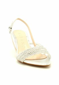 Sandalo slingback argento con una finitura metallica lucida, con una fascia decorata di gioielli sul davanti e una soletta beige morbida.
