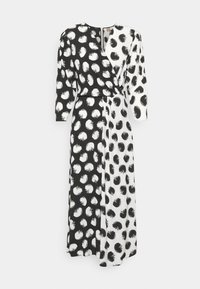 Długa sukienka typu wrap z rozcięciem, składająca się z czarno-białych sekcji, z każdą ozdobioną kontrastowymi wzorami abstrakcyjnymi. W komplecie długie rękawy.