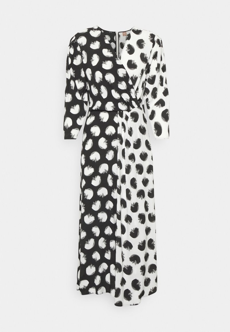 Długa sukienka typu wrap z rozcięciem, składająca się z czarno-białych sekcji, z każdą ozdobioną kontrastowymi wzorami abstrakcyjnymi. W komplecie długie rękawy.