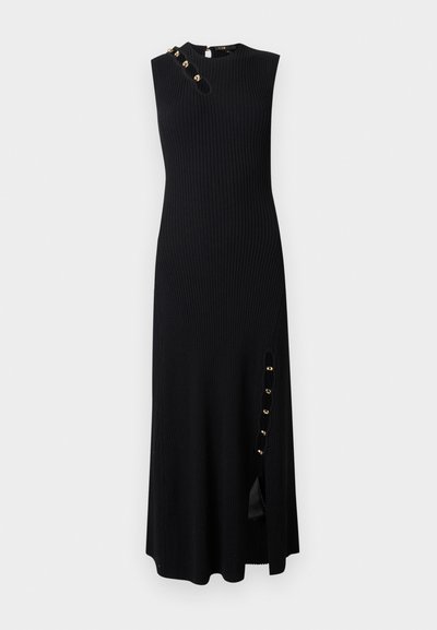 Robe midi noire sans manches en tissu côtelé, avec des boutons dorés près de l'ouverture à l'épaule gauche et une fente latérale avec des boutons.