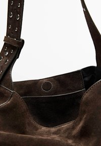 Borsa a spalla in suede marrone con forma a bordo arrotondato, superficie texturizzata, dettaglio con chiusura circolare e accentuazioni del manico perforate.