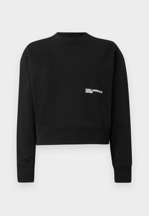 Must värvitud lühendatud särk pehme kangaga, ümmarguse kaelusega, pikkade varrukatega ja valge logo "KARL LAGERFELD JEANS" rinnal.