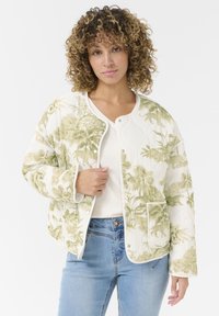 Veste matelassée blanche avec imprimé botanique vert, dotée d'un col rond, d'une fermeture à pression à l'avant et de poches latérales. Texture de tissu douce.