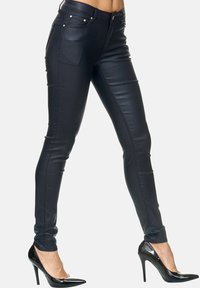 Zwarte nepleder skinny jeans met een glanzende afwerking, voorzien van gouden hardware en een aansluitend ontwerp dat naar de enkels toe smaller wordt.