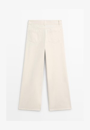 Off-white wijde broek met ceintuurlussen, twee achterzakken en zichtbare naden, plat neergelegd op een witte achtergrond.