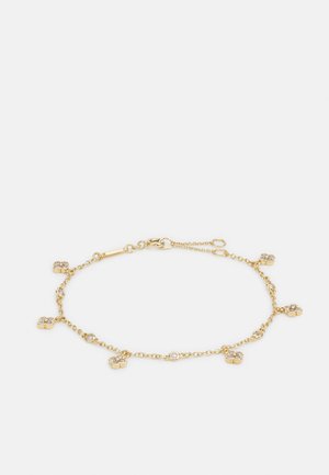 Bracciale d'oro con design a catena caratterizzato da accenti a forma di trifoglio distribuiti uniformemente, ciascuno decorato con brillanti pietre preziose trasparenti.