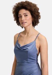 Satijnen jurk met kraag in zachtblauw, voorzien van dunne bandjes en een gedrapeerd ontwerp. Soepele textuur met een getailleerde pasvorm en geplooide accenten.