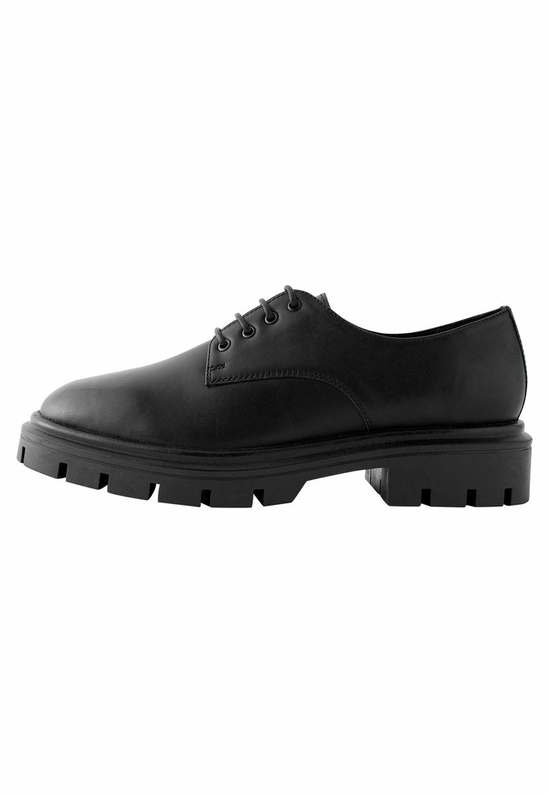 Scarpa in pelle nera con punta rotonda, design con lacci e suola in gomma spessa e testurizzata con bordi frastagliati.