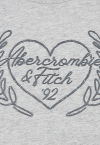 Felpa grigia con un design a forma di cuore con la scritta "Abercrombie & Fitch" e "’92" in lettere scure e lucenti, circondato da accenti di foglia.
