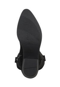 Botín negro hasta el tobillo con punta afilada, parte superior texturizada y suela de goma con estrías horizontales para mayor tracción. Cierre lateral con cremallera incluido.