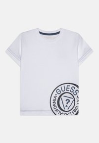Camiseta de algodón blanca de manga corta, con un diseño de logo impreso en azul en la parte delantera y costuras en contraste a lo largo de las mangas.
