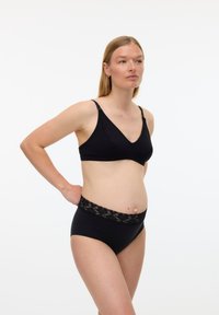 Μαύρο ασύρματο σουτιέν με ντεκολτέ σε σχήμα V και ρυθμιζόμενους ιμάντες, σετ με μαύρο ψηλόμεσο εσώρουχο με ζώνη από λουλουδάτη δαντέλα.