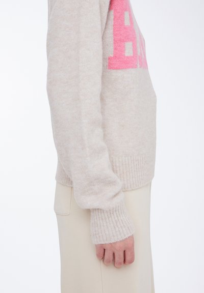 Beige sweater lavet af blødt materiale, med et lyserødt grafisk design. Ermene har ribbede manchetter og en afslappet pasform.