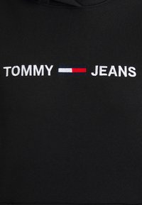 Černá mikina s bílým vyšitým nápisem "TOMMY" a "JEANS" a barevným pruhovaným logem v námořnické modři, bílé a červené.