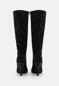 Stivali neri in camoscio fino al ginocchio con punta a punta, adornati con scintillanti strass, caratterizzati da un tacco alto sottile e cerniere posteriori.