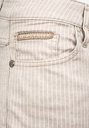 Jeans in denim grigio chiaro con strisce bianche verticali, caratterizzati da un piccolo dettaglio tasca, hardware argentato e un'etichetta in tessuto con il brand.