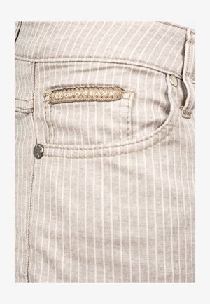 Vaqueros de mezclilla gris claro con rayas blancas verticales, que cuentan con un pequeño detalle de bolsillo, herrajes plateados y una etiqueta de tela con marca.