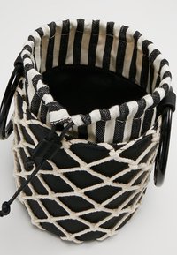 Czarna torba typu bucket z plecionym wzorem. Wyposażona w podszewkę z paskowanej tkaniny oraz czarne okrągłe uchwyty. Wykonana z teksturowanej bawełny i skóry.