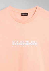 Pfirsichfarbene Baumwoll-T-Shirt mit Rundhalsausschnitt, versehen mit einem weißen rechteckigen Logo, auf dem der Text "NAPAPIJRI geographical" mittig gedruckt ist.