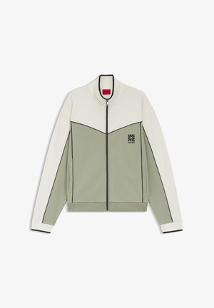 Kurtka na zamek z kremową górą i rękawami, jasnozieloną dolną częścią, czarną lamówką, bocznymi kieszeniami i małym czarnym logo na piersi.