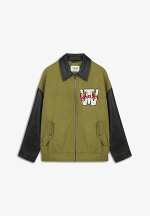 Olive green jacket with black leather sleeves, zip closure, two front pockets, embroidered "TW" and "forever" details.