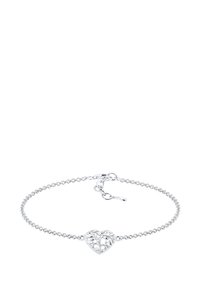 Silverbandsarmband med en fin kedja och ett hjärtformat hänge med en utskuren trädesign. Spännet är säkert och funktionellt.