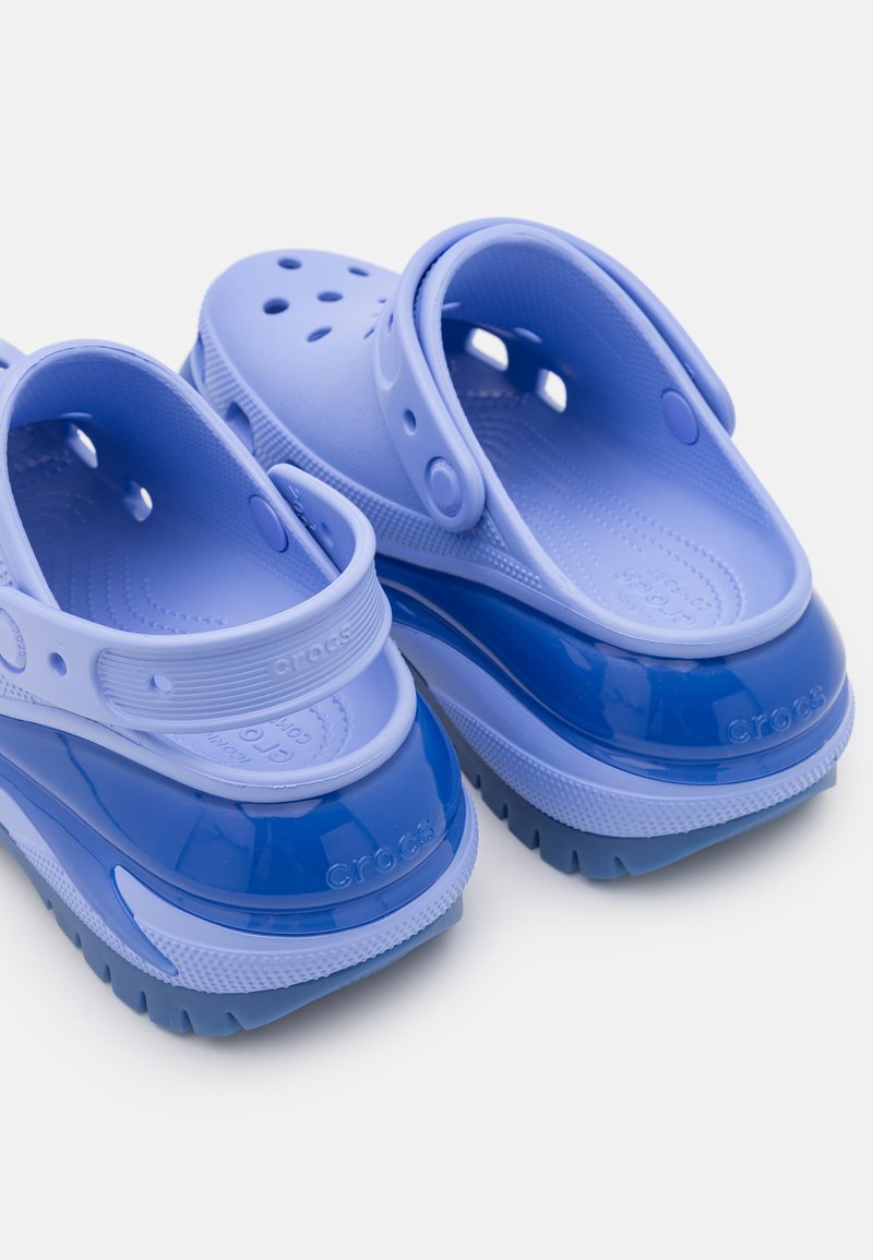 Niebieskie klapki z gumy o błyszczącej powierzchni, z otworami wentylacyjnymi, regulowanym paskiem z tyłu i teksturowaną wkładką dla komfortu.