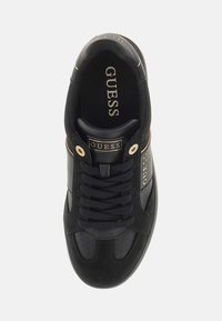 Tenis negri cu partea superioară din piele texturată, accente aurii, limbă cu marcă și panouri laterale perforate. Design standard cu șireturi.