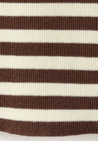 Gros plan sur des rayures horizontales tricotées marron et blanches sur un tissu côtelé.