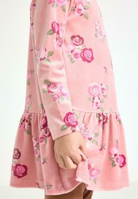 Pink floral dress made of soft fabric, featuring long sleeves, a gathered skirt, and rose patterns in shades of pink and green.