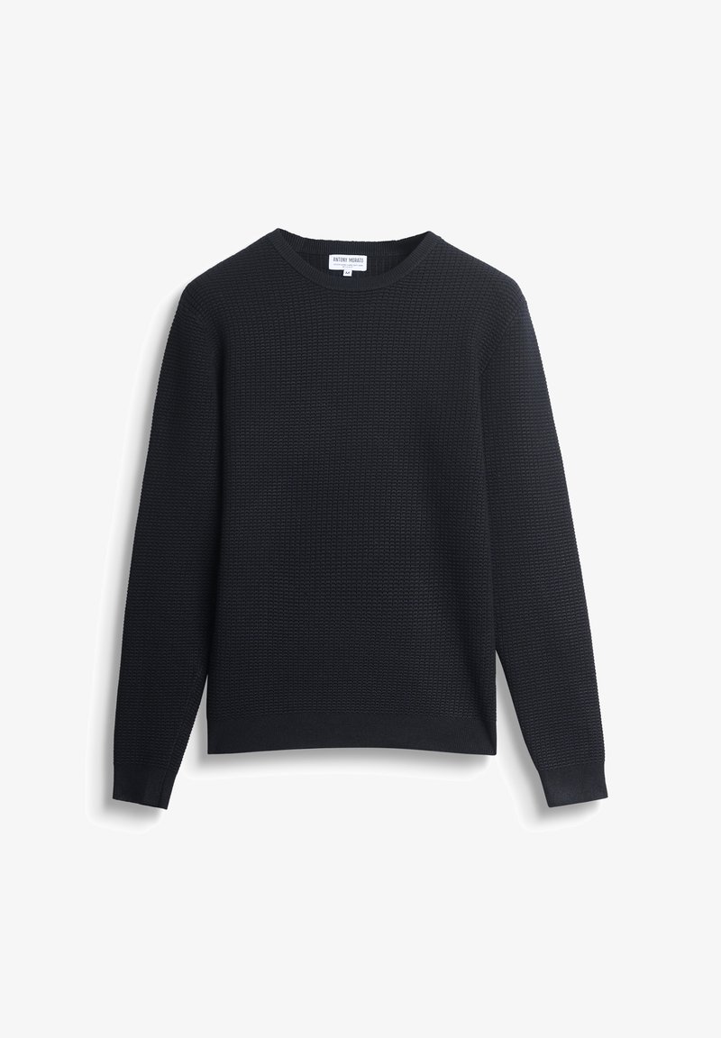 Zwarte, textuurgebreide ronde hals trui met lange mouwen, plat gelegd op een witte achtergrond.