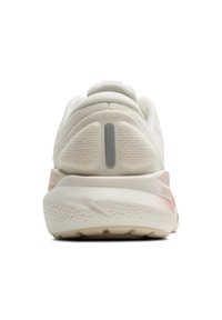 Baltas sporta apavi ar teksturētu virsmu, izteiktu papēža amortizāciju un gaiši rozā akcentu uz zoles ar atstarotāju.