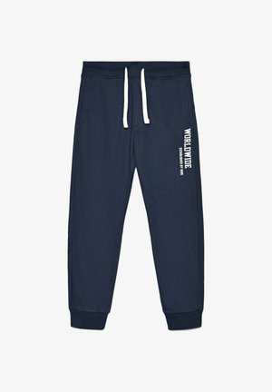 Pantaloni della tuta blu navy con vita elastica e coulisse bianche. Presenta tasche laterali e testo stampato lungo la gamba sinistra.