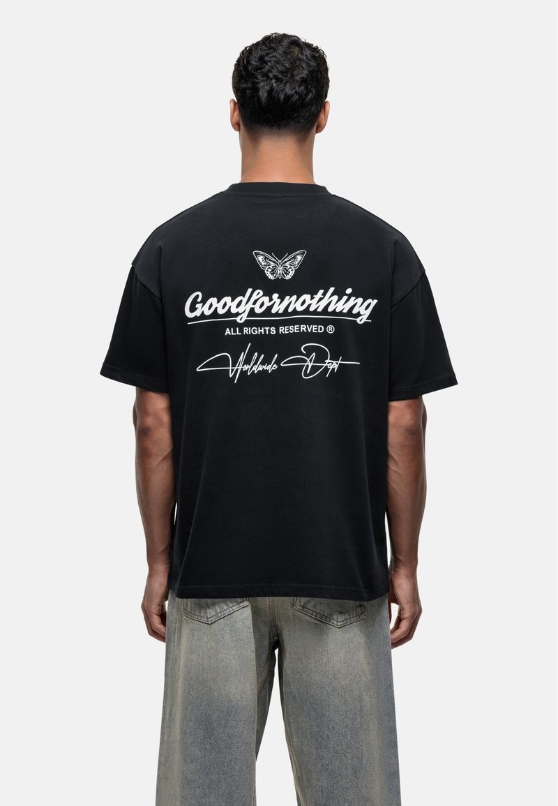 Czarna bawełniana koszulka z oversize'owym krojem, z białym napisem "Goodfornothing" oraz grafiką motyla na plecach. Luźny krój.