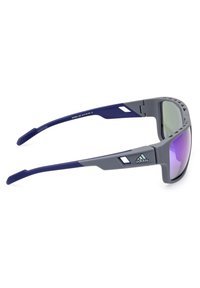 Adidas aurinkolasit, joissa on harmaa runko ja siniset yksityiskohdat, peilipinnalla varustetut linssit, ympärille muotoiltu suunnittelu ja teksturoitu ote varsissa.