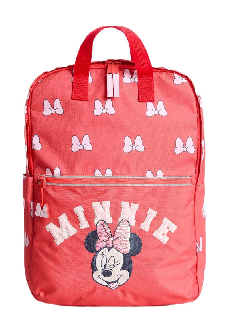 Röd tygryggsäck med vita snöre-mönster. Har en framficka med blixtlås där det står "MINNIE" och en broderad design av Musse Piggs väninna, Minnie.