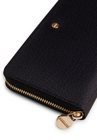 Portafoglio nero con zip in materiale testurizzato, dotato di una cerniera dorata e di un distintivo rotondo dorato con il nome del marchio.