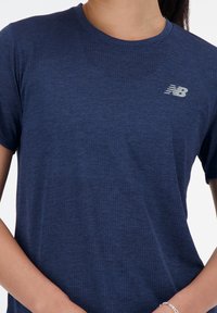 Ναυτικό κοντομάνικο μπλουζάκι με υφή, που διαθέτει ένα ανακλαστικό λογότυπο "Ν" στην επάνω αριστερή πλευρά του στήθους. Μαλακό, ανάλαφρο ύφασμα.