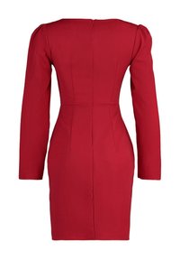 Robe rouge ajustée à manches longues avec une fermeture éclair dans le dos, des épaules structurées et un ourlet à hauteur des genoux.