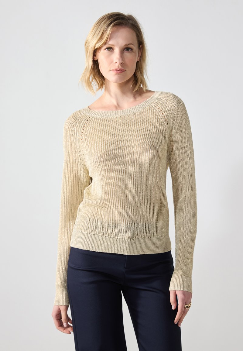 Strikket beige genser med bred utrigning, lange ermer og ribbede mansjetter. Har et teksturert mønster hele veien og en avslappet passform.