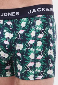 Chiloți tip boxer cu un fundal bleumarin și modele roz cu flamingo și flori, realizați dintr-un material moale, cu o talie contrastantă inscripționată "JACK & JONES".