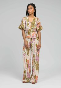 Ensemble à motifs en deux pièces comprenant un top enroulé à manches courtes et un pantalon large taille haute aux dessins floraux de couleur crème, vert, rose et violet.